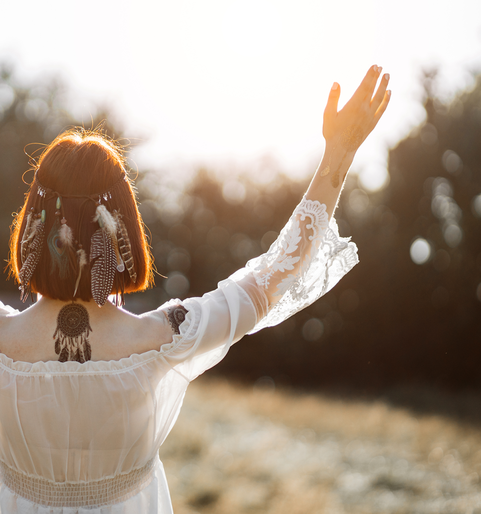 woman with her hands in the air wearing a white dress